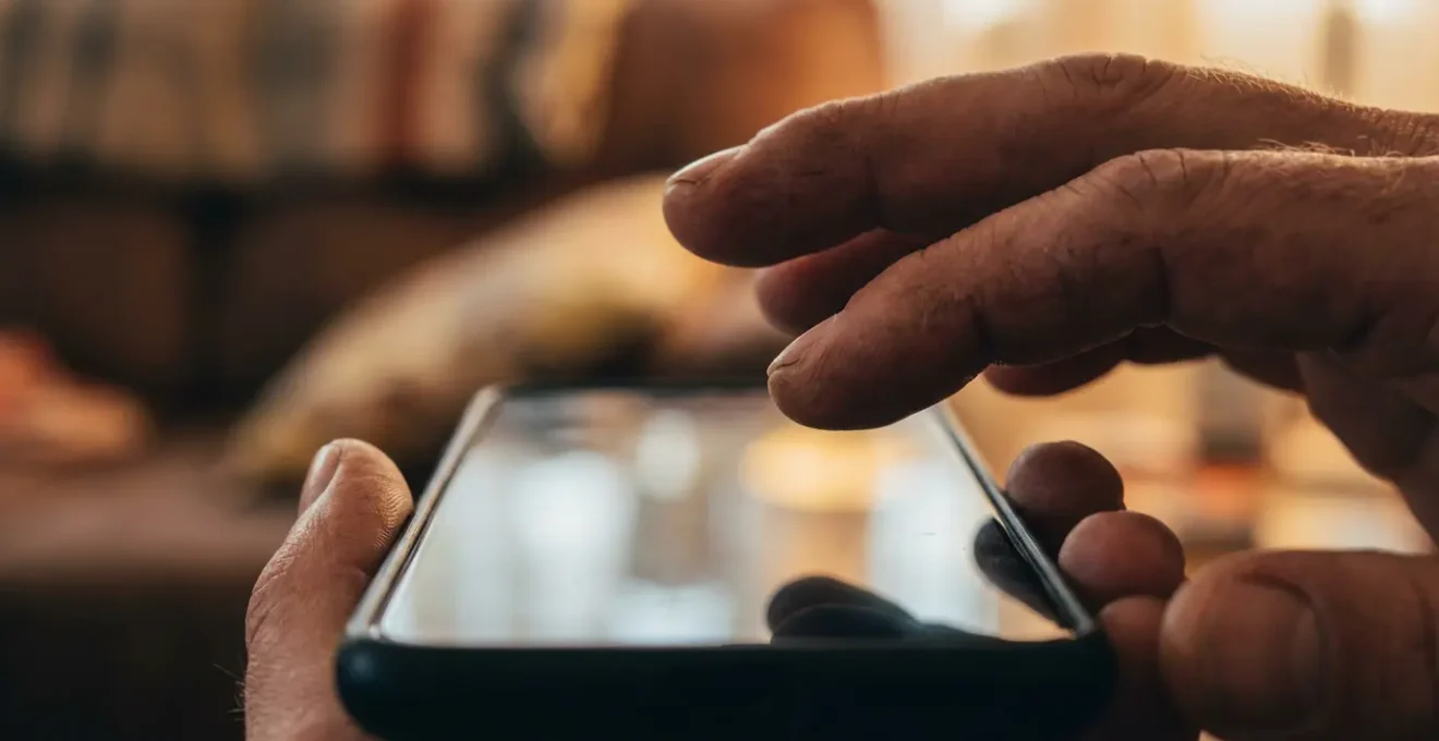 Mains tenant un smartphone avec des gestes expressifs suggérant une conversation dynamique et créative.