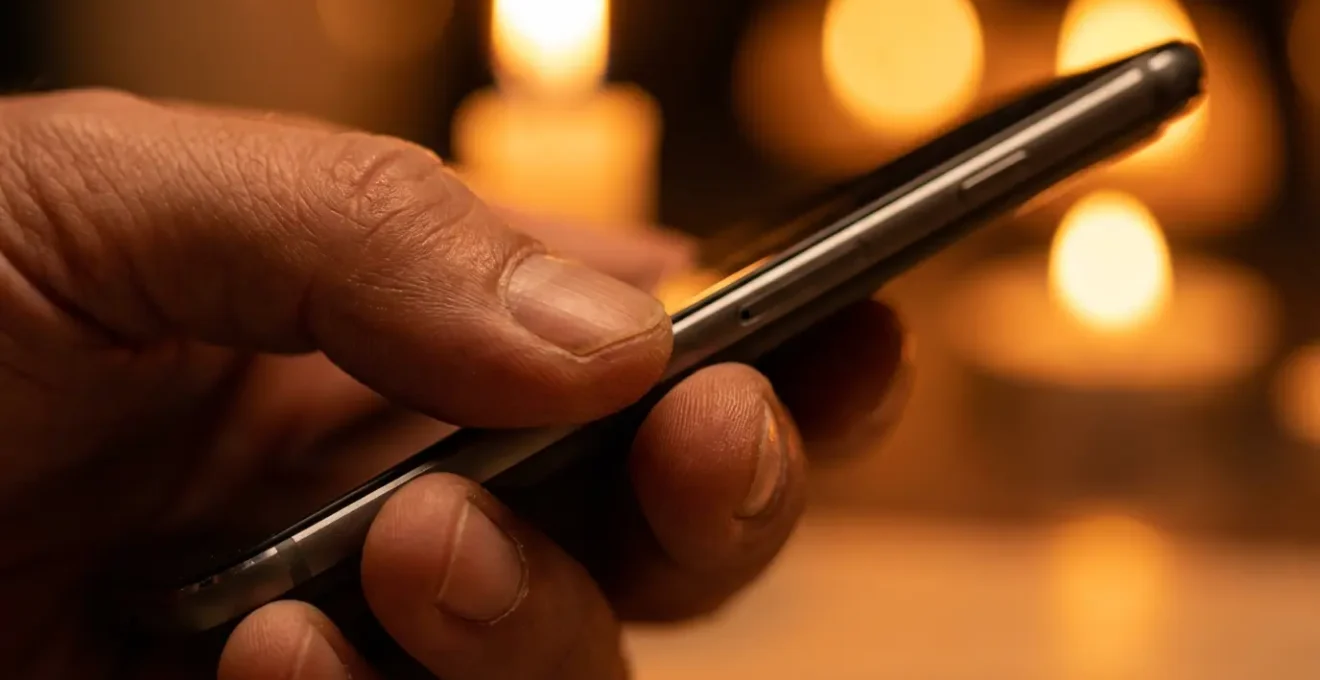 Mains tenant un téléphone dans une lumière douce créant une atmosphère intime