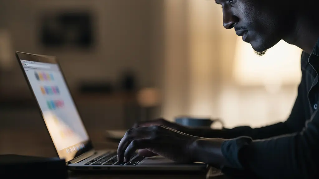 Personne effectuant une recherche sur un ordinateur portable vu de côté avec écran flou